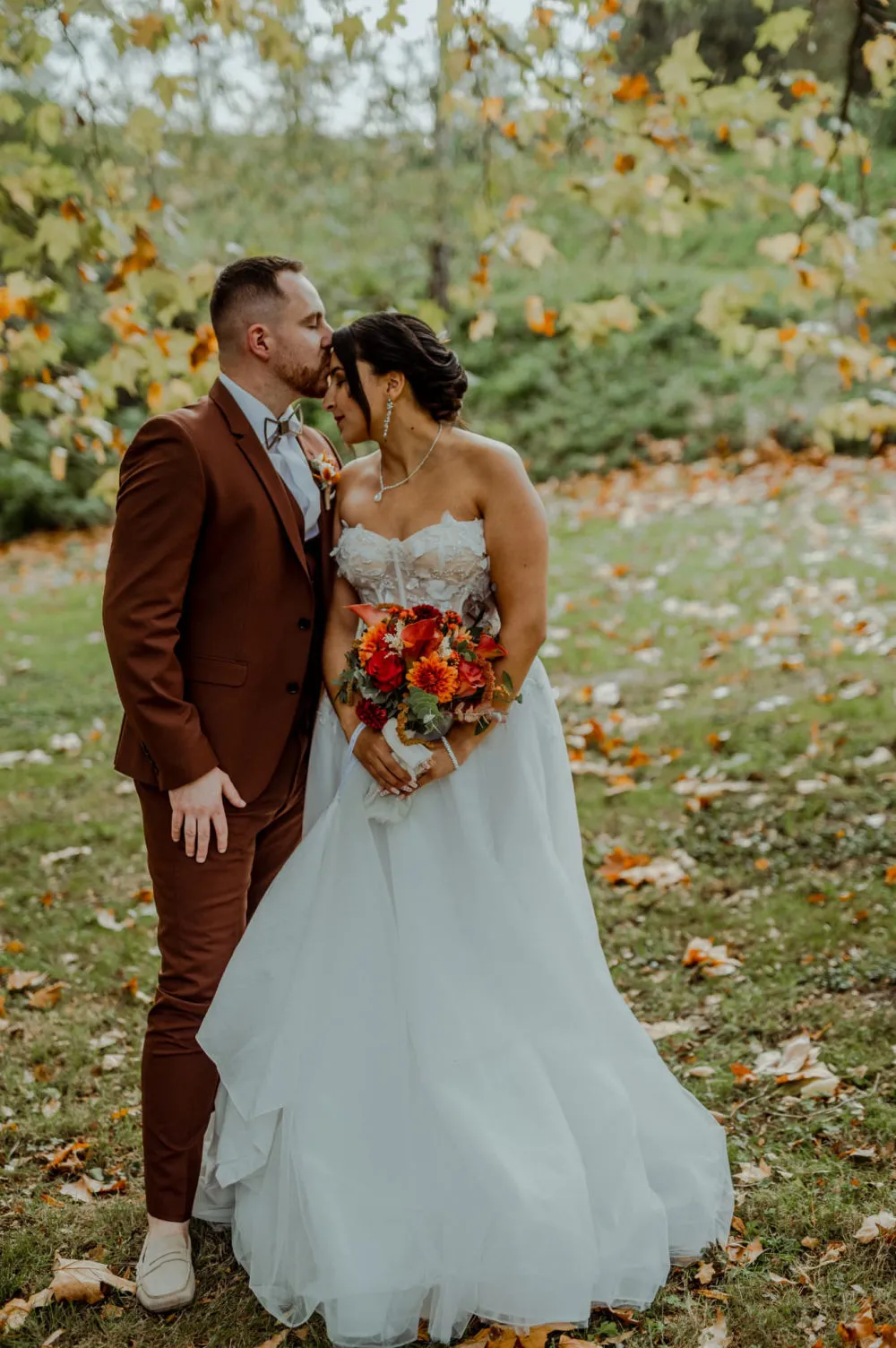 Couple de mariés en automne, bouquet coloré