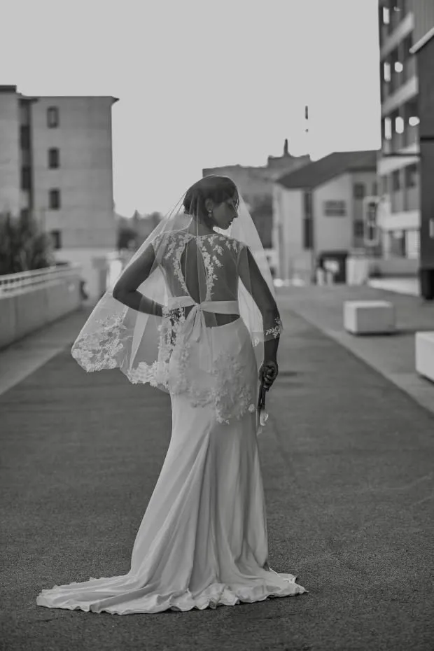 Mariée de dos avec voile et dentelle, photo noir et blanc